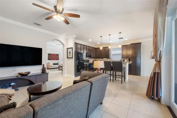 a living room with furniture kitchen view and a flat screen tv