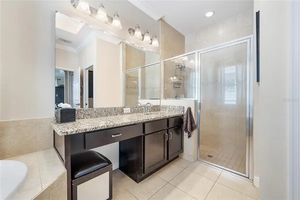 a bathroom with a granite countertop sink a mirror and a shower