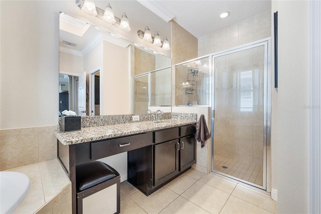 4436 Azure Isle Way Kissimmee, FL 34744 - Photo 24 of 35 a bathroom with a granite countertop sink a mirror and a shower