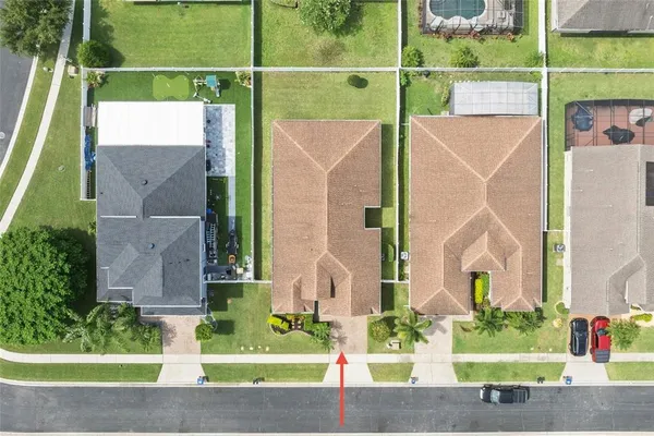 a view of a house with a small yard and a large tree