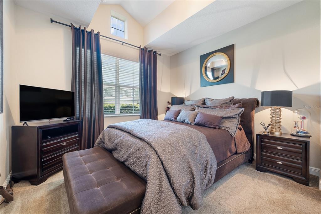 4436 Azure Isle Way Kissimmee, FL 34744 - Photo 4 of 35 a bedroom with a bed and a flat screen tv