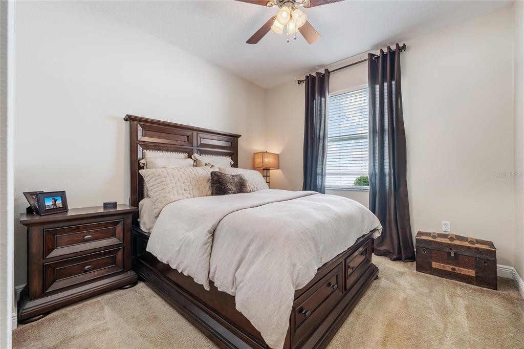 4436 Azure Isle Way Kissimmee, FL 34744 - Photo 6 of 35 a bed sitting in a bedroom next to a window