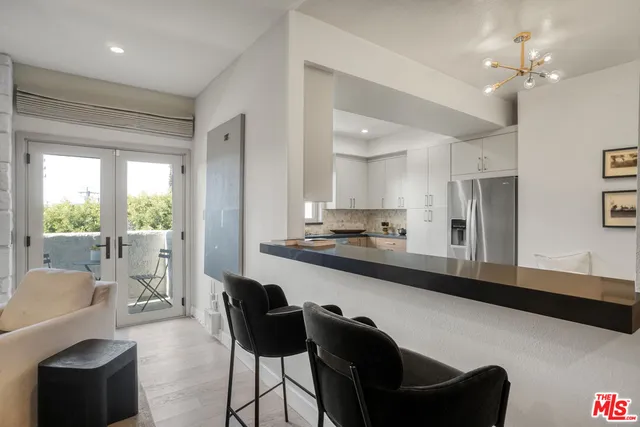 a living room with stainless steel appliances kitchen island granite countertop furniture and a large window