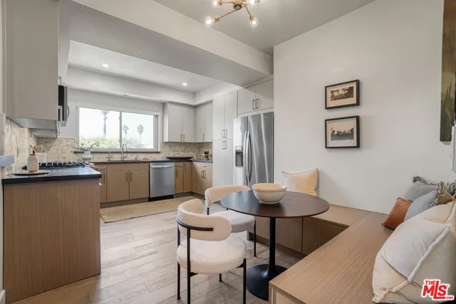 a kitchen with stainless steel appliances granite countertop a sink a stove a refrigerator cabinets and a window