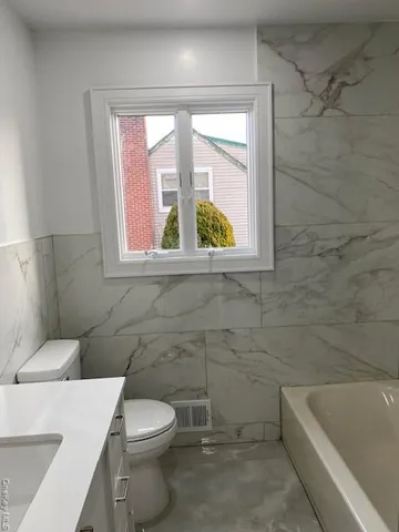 a bathroom with a toilet a sink and bathtub