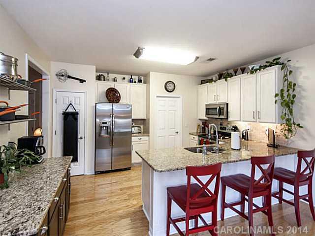 4920 Missi Lane Fort Mill, SC 29708 - Photo 5 of 16 a kitchen with stainless steel appliances kitchen island granite countertop a table chairs and a refrigerator