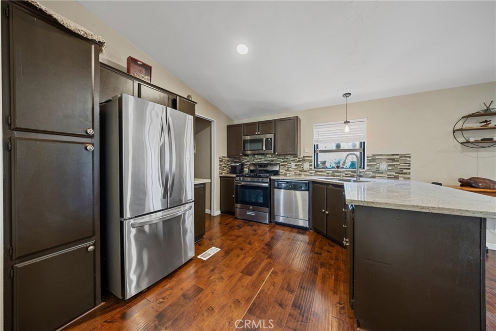 34437 Tree Lane Wildomar, CA 92595 - Photo 8 of 42 a kitchen with stainless steel appliances wooden floor sink and refrigerator