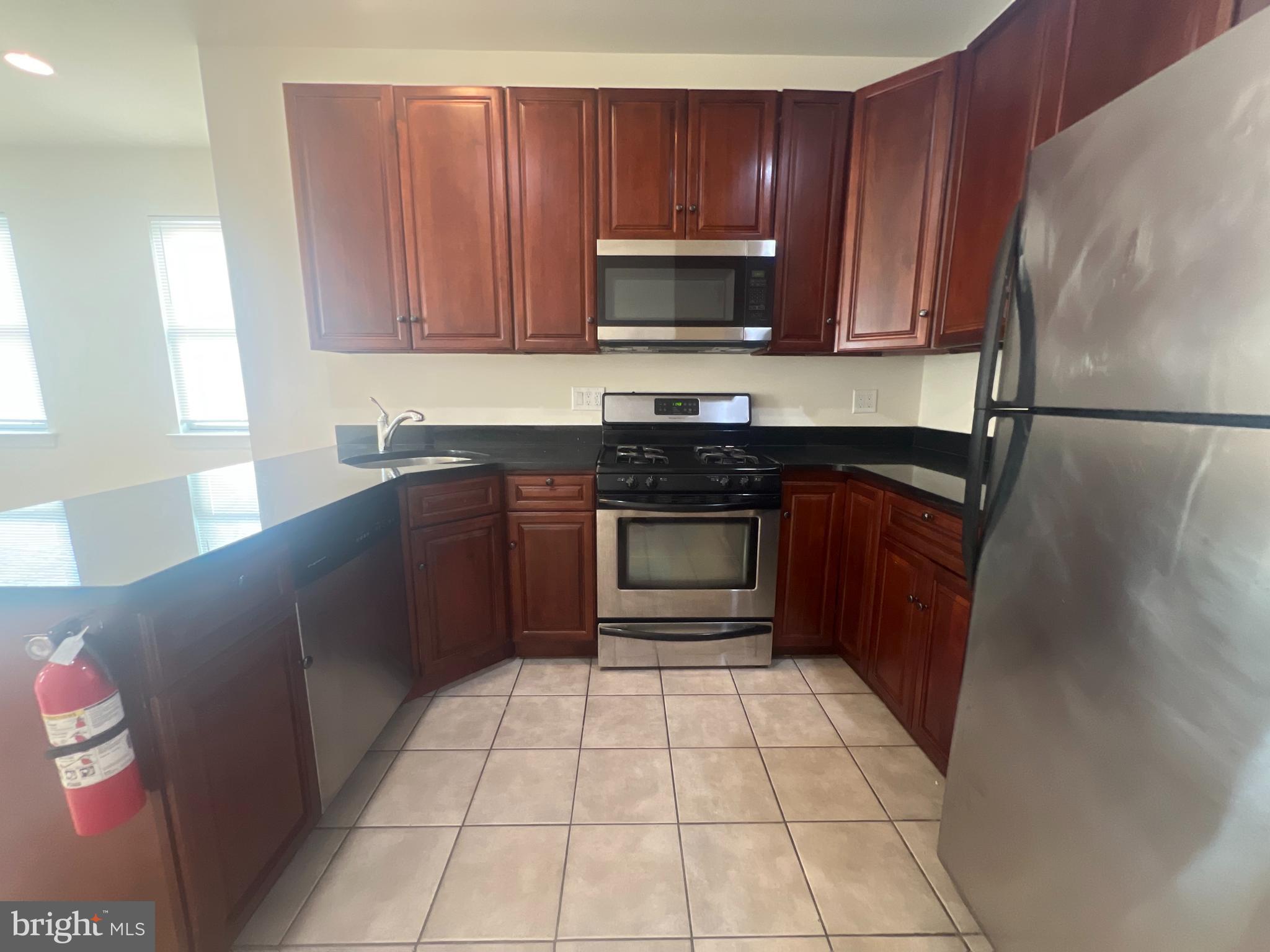 1930 North 17th Street, Unit B Philadelphia, PA 19121 - Photo 3 of 7 a kitchen with stainless steel appliances granite countertop a refrigerator and a stove top oven