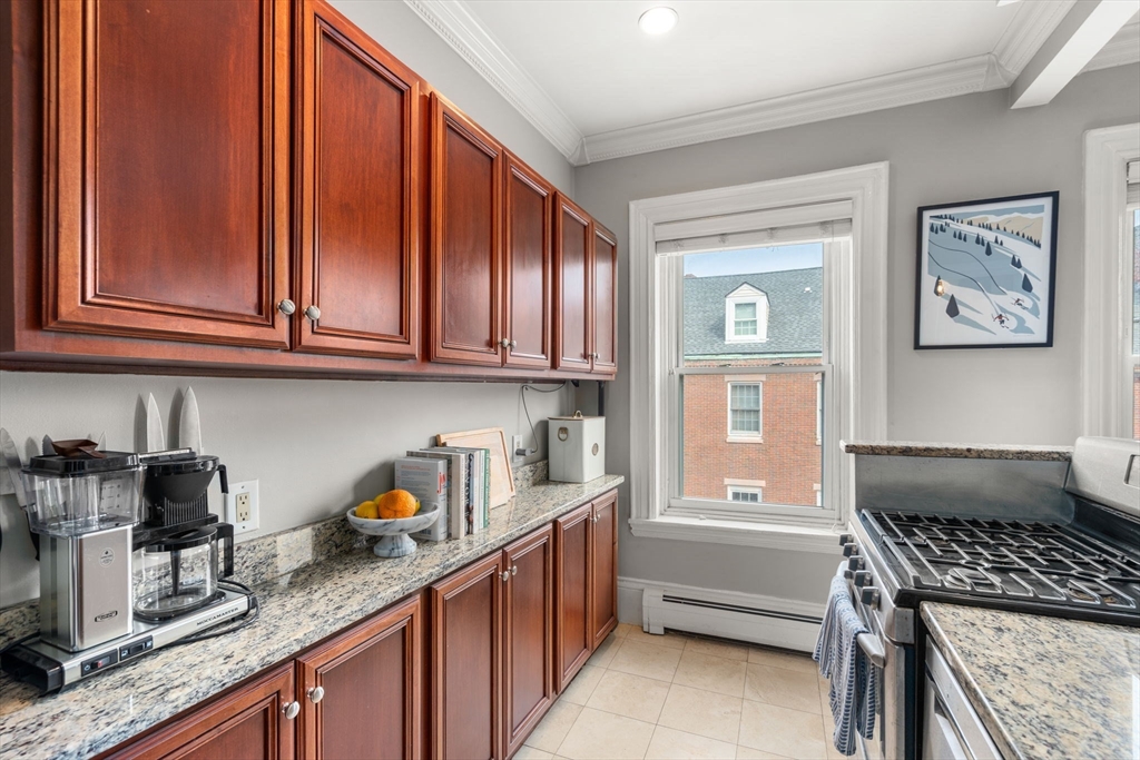 18 Harvard Street, Unit 3 Boston, MA 02129 - Photo 7 of 15 a kitchen with granite countertop cabinets and window