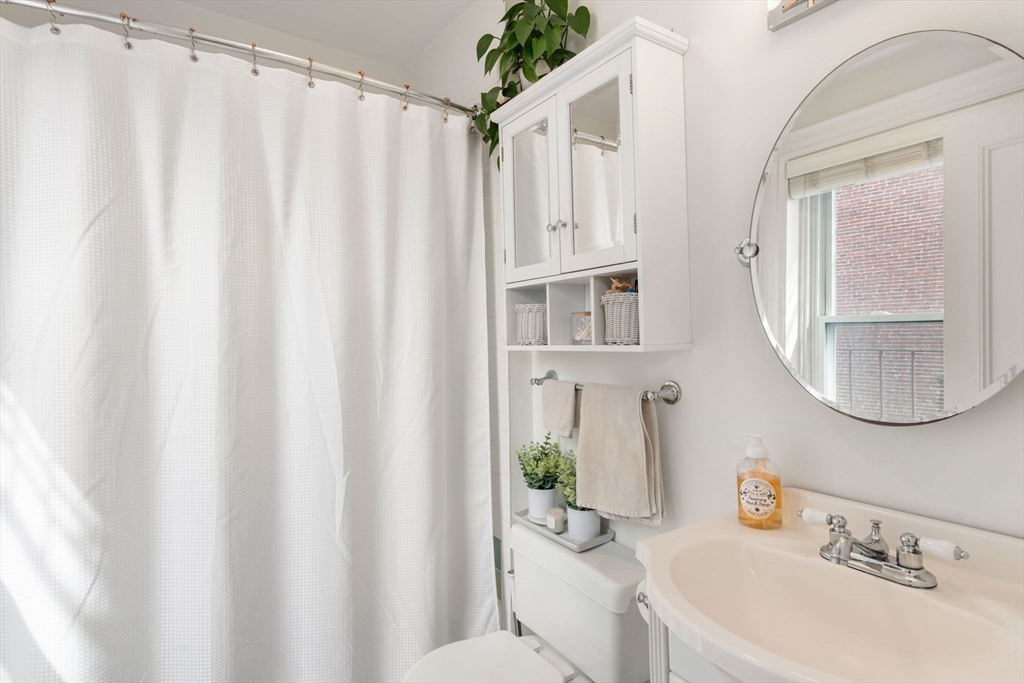 18 Harvard Street, Unit 3 Boston, MA 02129 - Photo 10 of 15 a bathroom with a sink a toilet and shower curtain