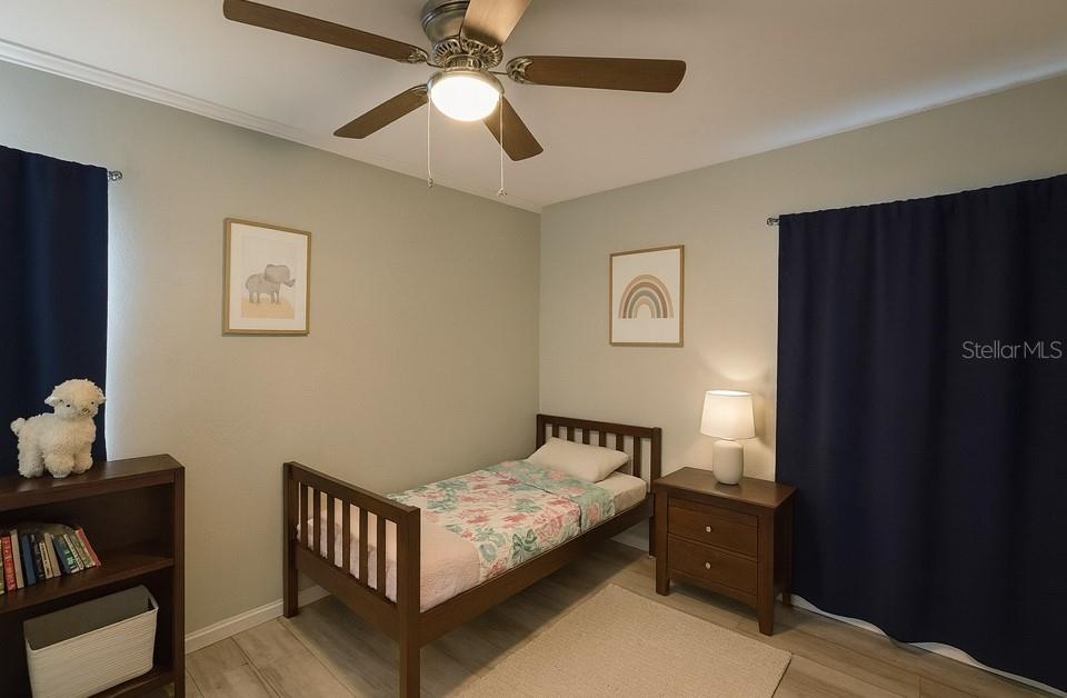 808 Derbyshire Road Daytona Beach, FL 32117 - Photo 5 of 23 a bedroom with a bed and wooden floor