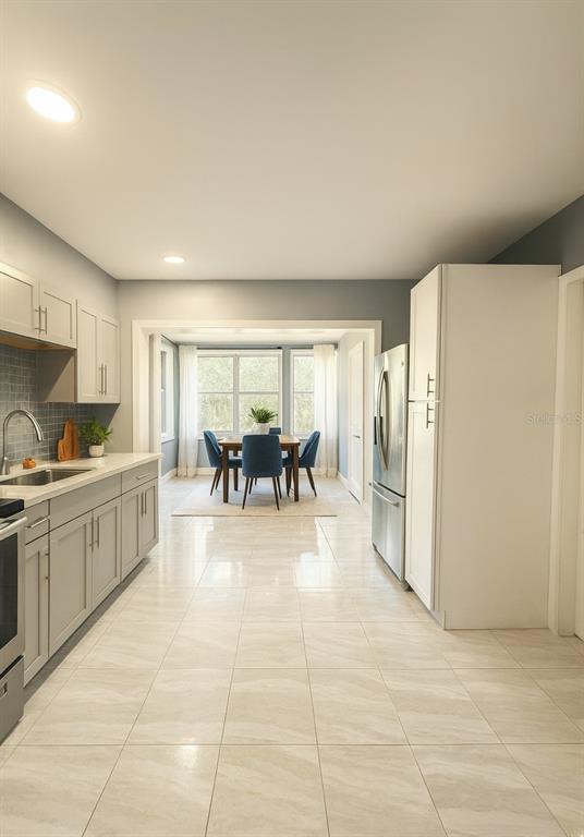 808 Derbyshire Road Daytona Beach, FL 32117 - Photo 6 of 23 a large white kitchen with cabinets and stainless steel appliances