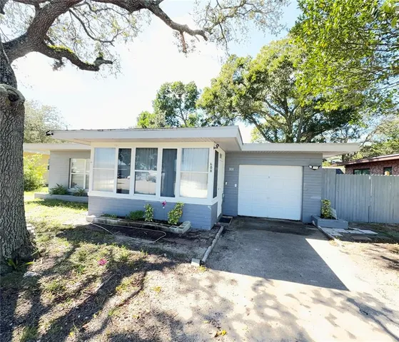 a front view of a house with a yard and outdoor seating