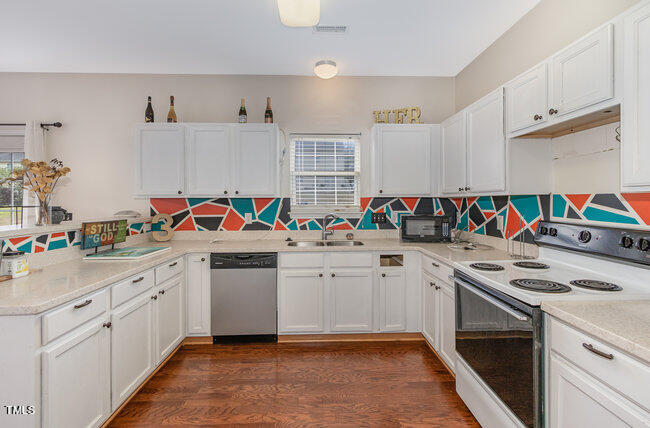 508 Summer Breeze Drive Durham, NC 27704 - Photo 12 of 28 a kitchen with granite countertop appliances a sink and cabinets
