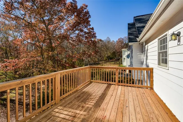 an empty room with wooden floor fireplace and windows
