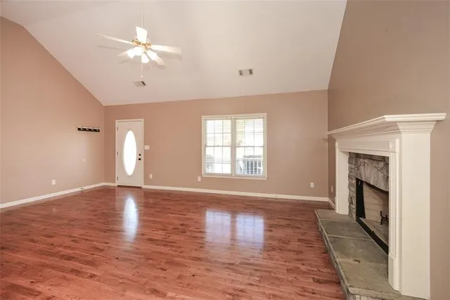 a kitchen with stainless steel appliances a sink a stove a refrigerator cabinets and a window