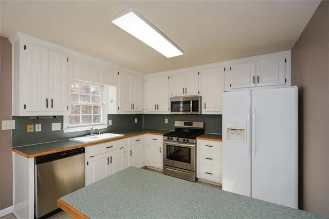 a kitchen with stainless steel appliances granite countertop a stove a sink and a refrigerator