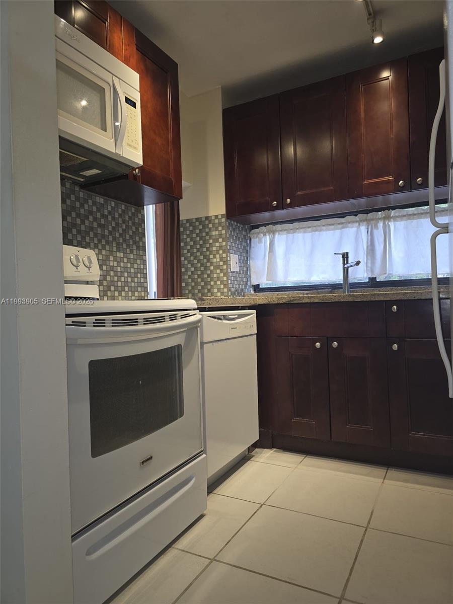 17021 North Bay Road, Unit 225 Sunny Isles Beach, FL 33160 - Photo 6 of 24 a kitchen with a sink and cabinets