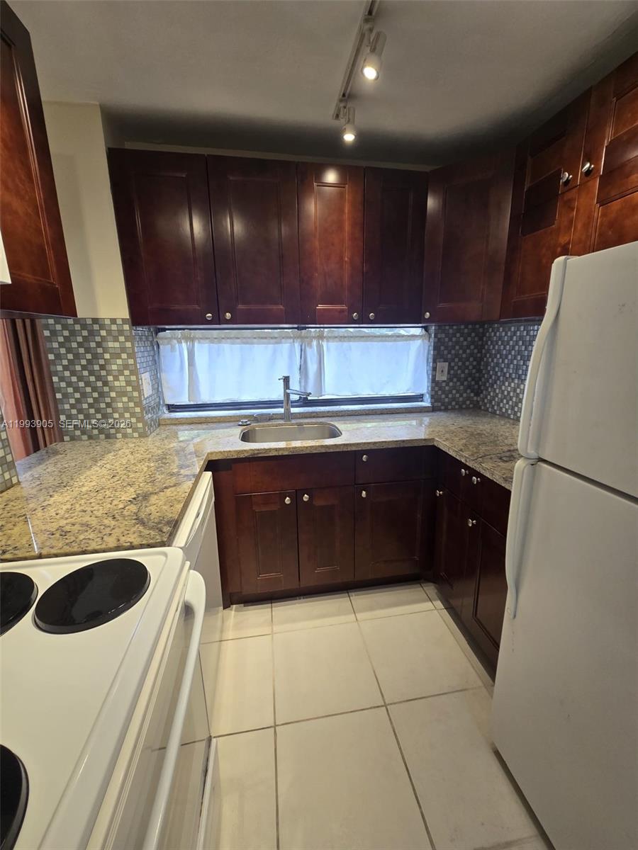 17021 North Bay Road, Unit 225 Sunny Isles Beach, FL 33160 - Photo 8 of 24 a kitchen with a sink and a refrigerator