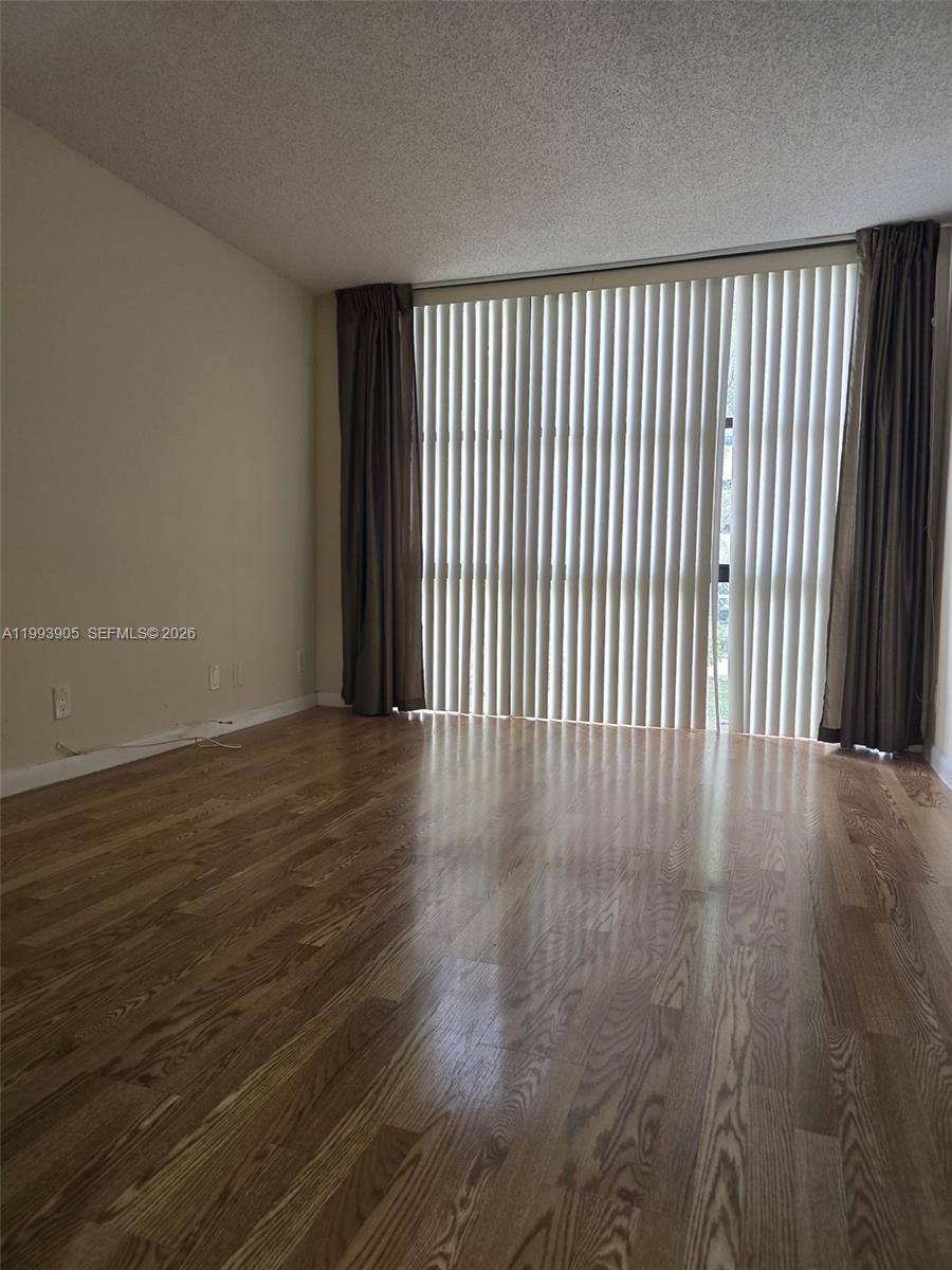 17021 North Bay Road, Unit 225 Sunny Isles Beach, FL 33160 - Photo 10 of 24 an empty room with wooden floor and windows