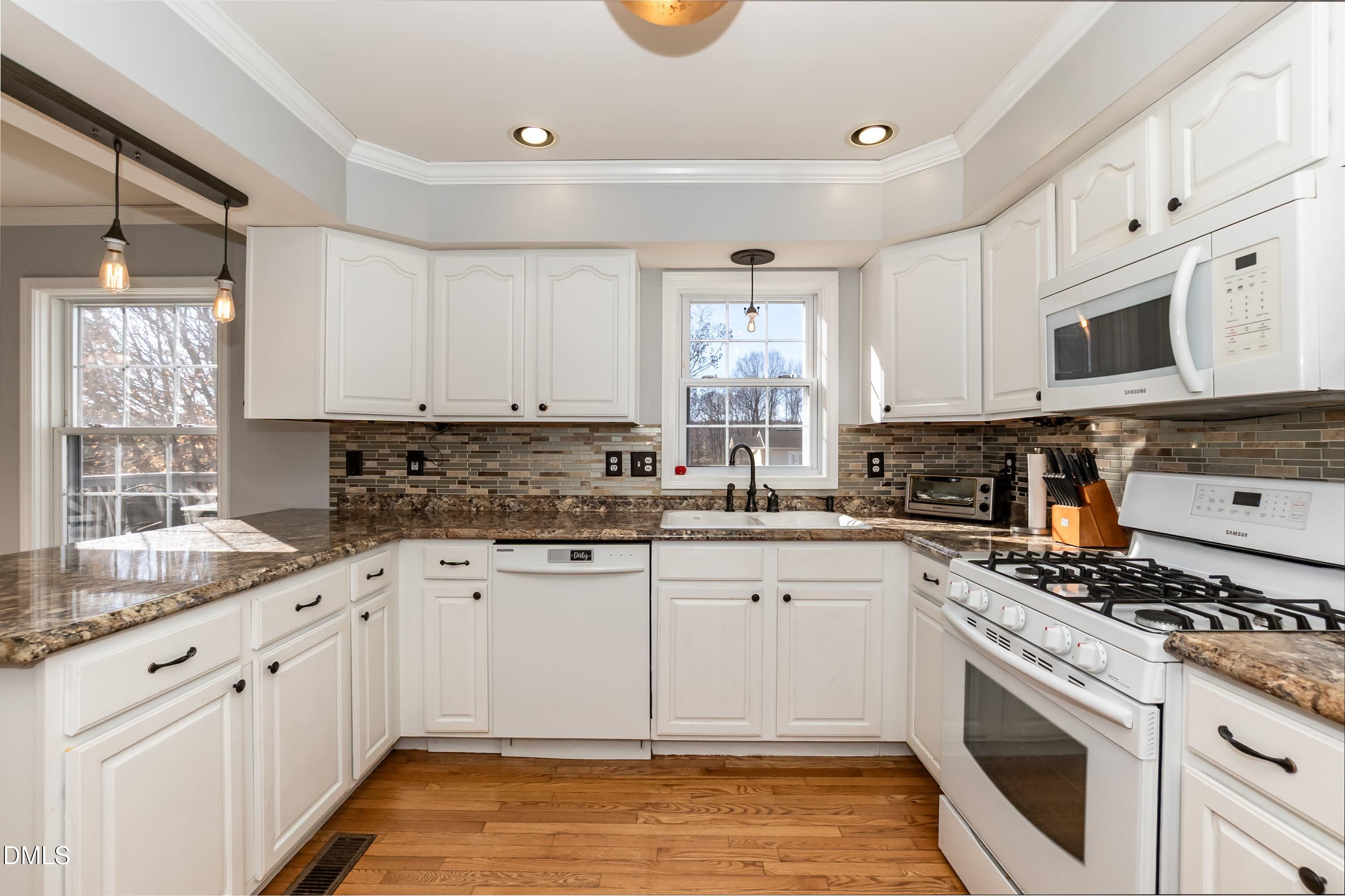 1722 Saddle Club Road Mebane, NC 27302 - Photo 12 of 37 a kitchen with granite countertop a sink a stove a microwave and cabinets