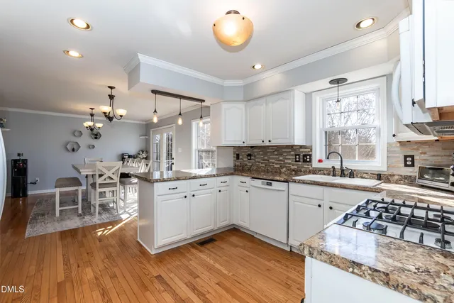 a kitchen with granite countertop a stove a sink and a dining table