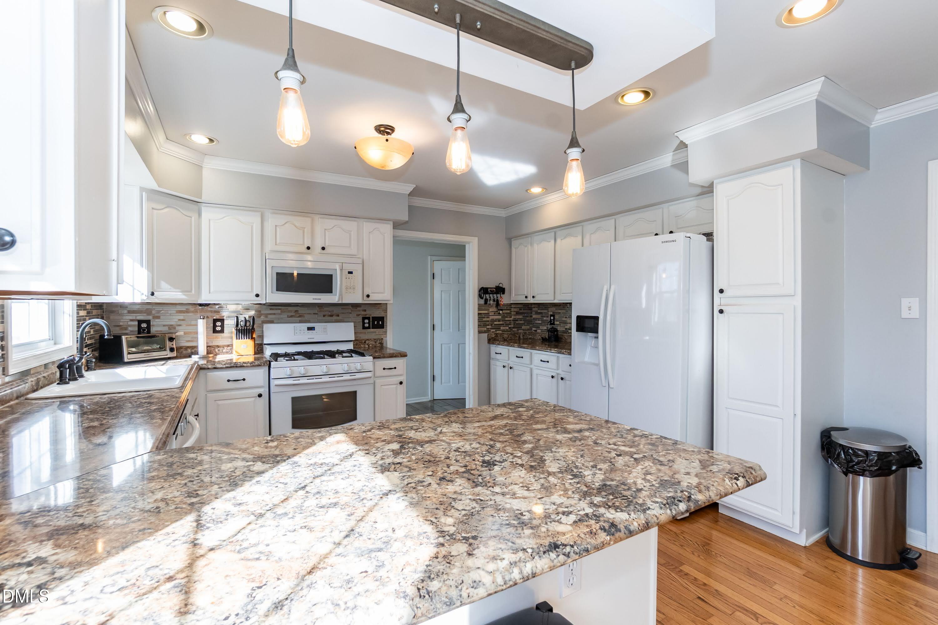 1722 Saddle Club Road Mebane, NC 27302 - Photo 9 of 37 a kitchen with stainless steel appliances kitchen island granite countertop a refrigerator a stove and a sink with granite countertops