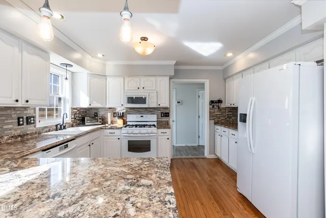 a kitchen with stainless steel appliances a refrigerator and a stove top oven