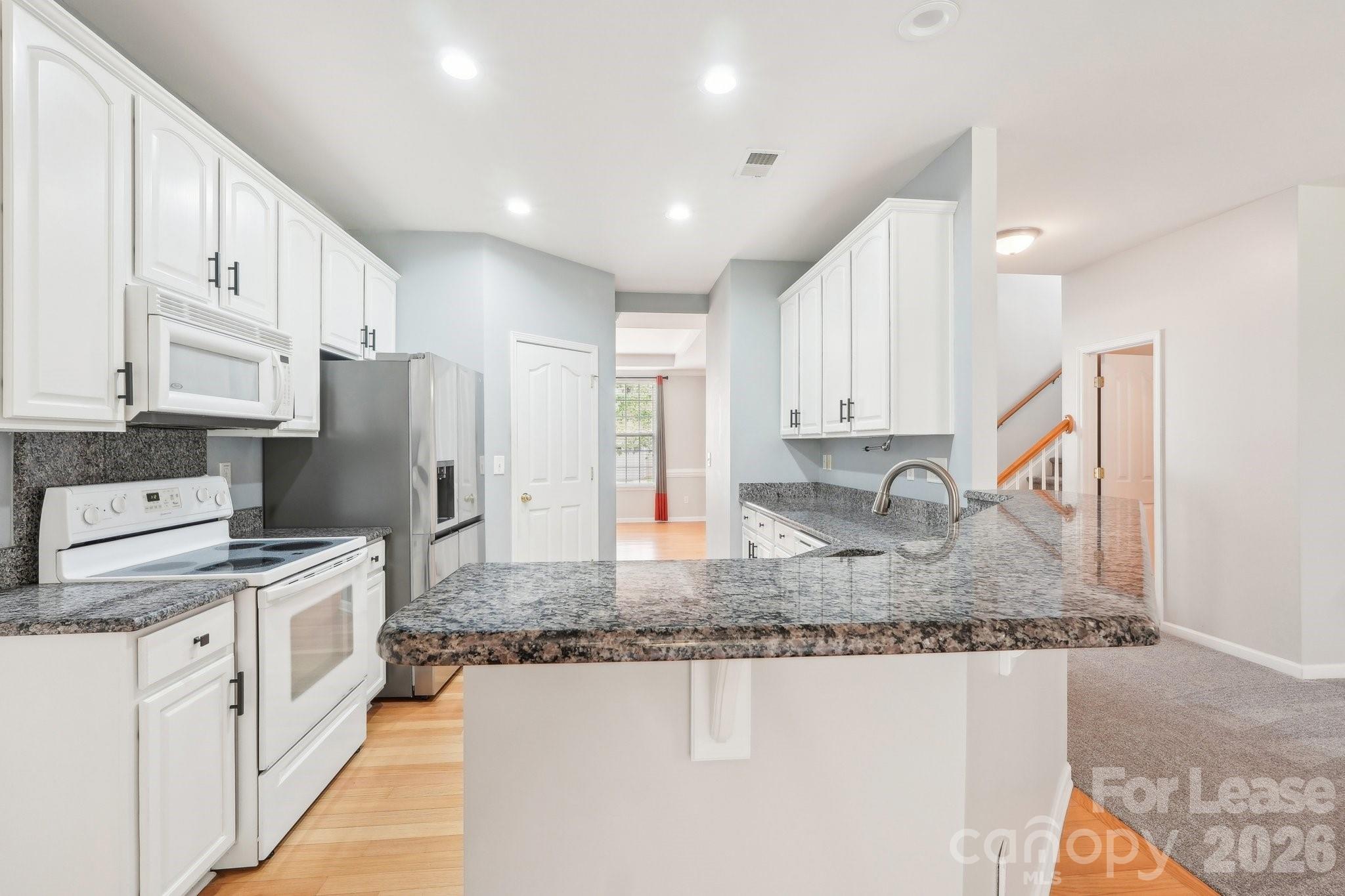 14417 Laurel Tree Lane Huntersville, NC 28078 - Photo 13 of 48 a kitchen with stainless steel appliances granite countertop a sink refrigerator and cabinets
