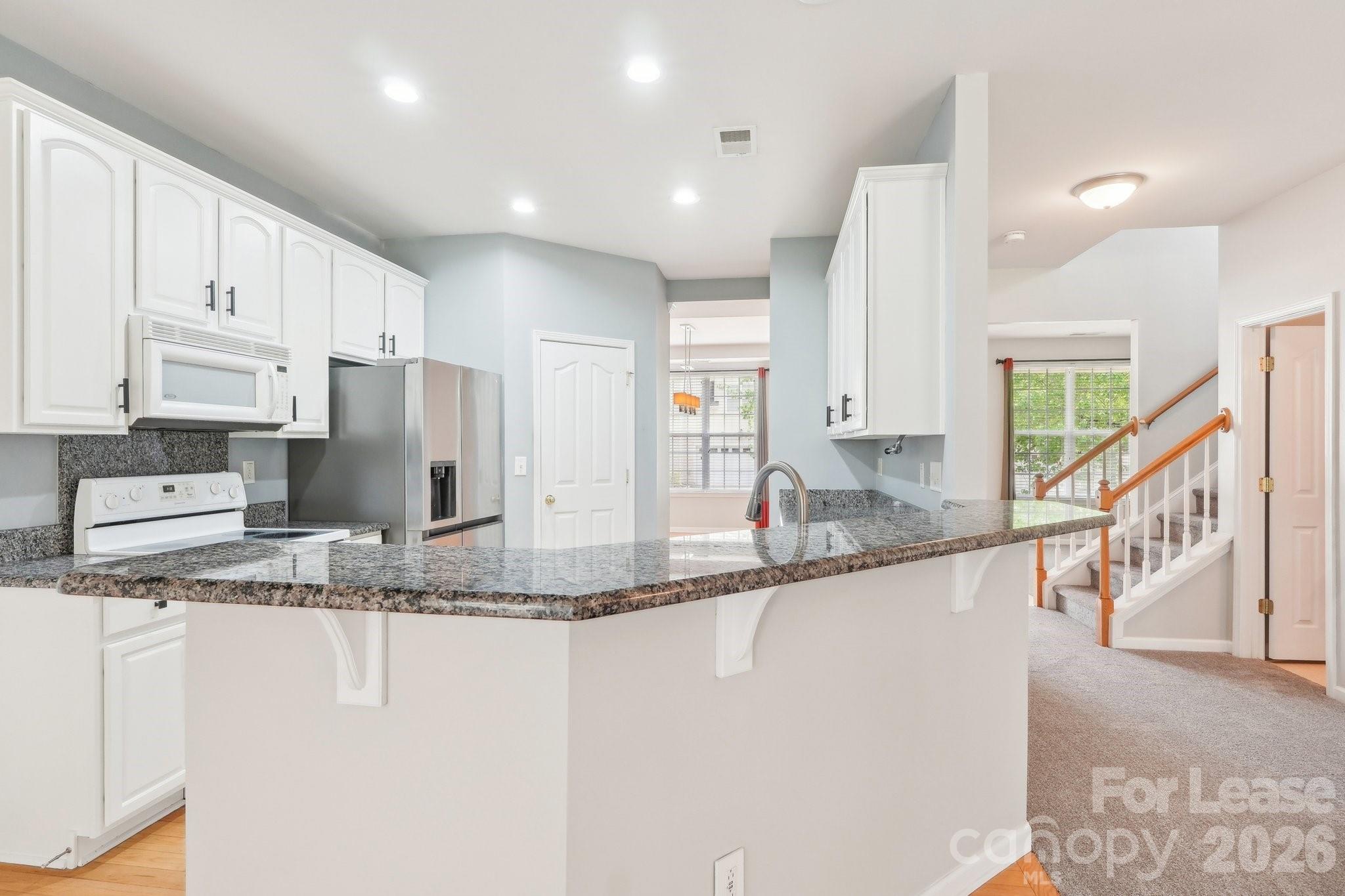 14417 Laurel Tree Lane Huntersville, NC 28078 - Photo 14 of 48 a kitchen with stainless steel appliances granite countertop a sink and a refrigerator