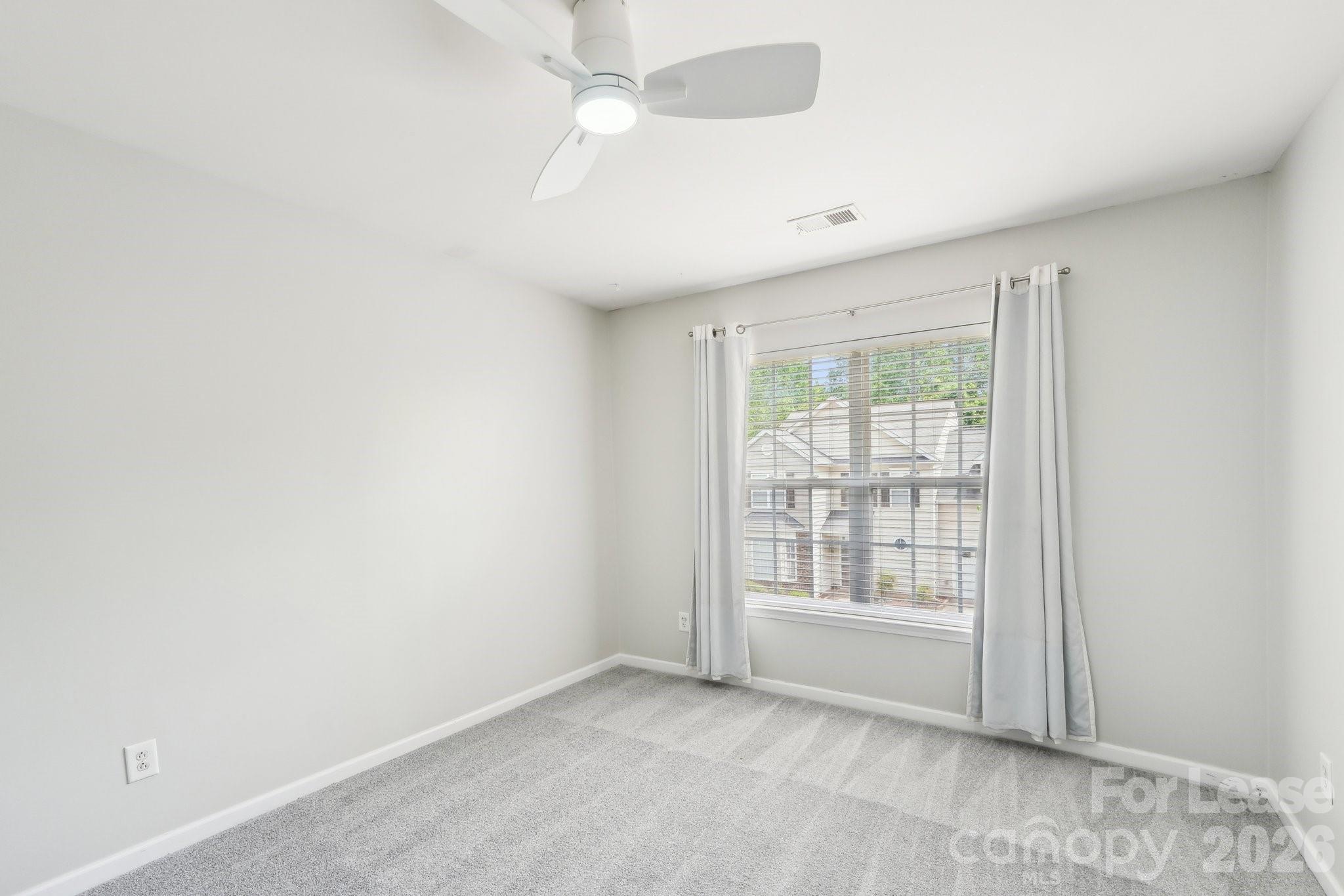 14417 Laurel Tree Lane Huntersville, NC 28078 - Photo 30 of 48 an empty room with chandelier fan and windows