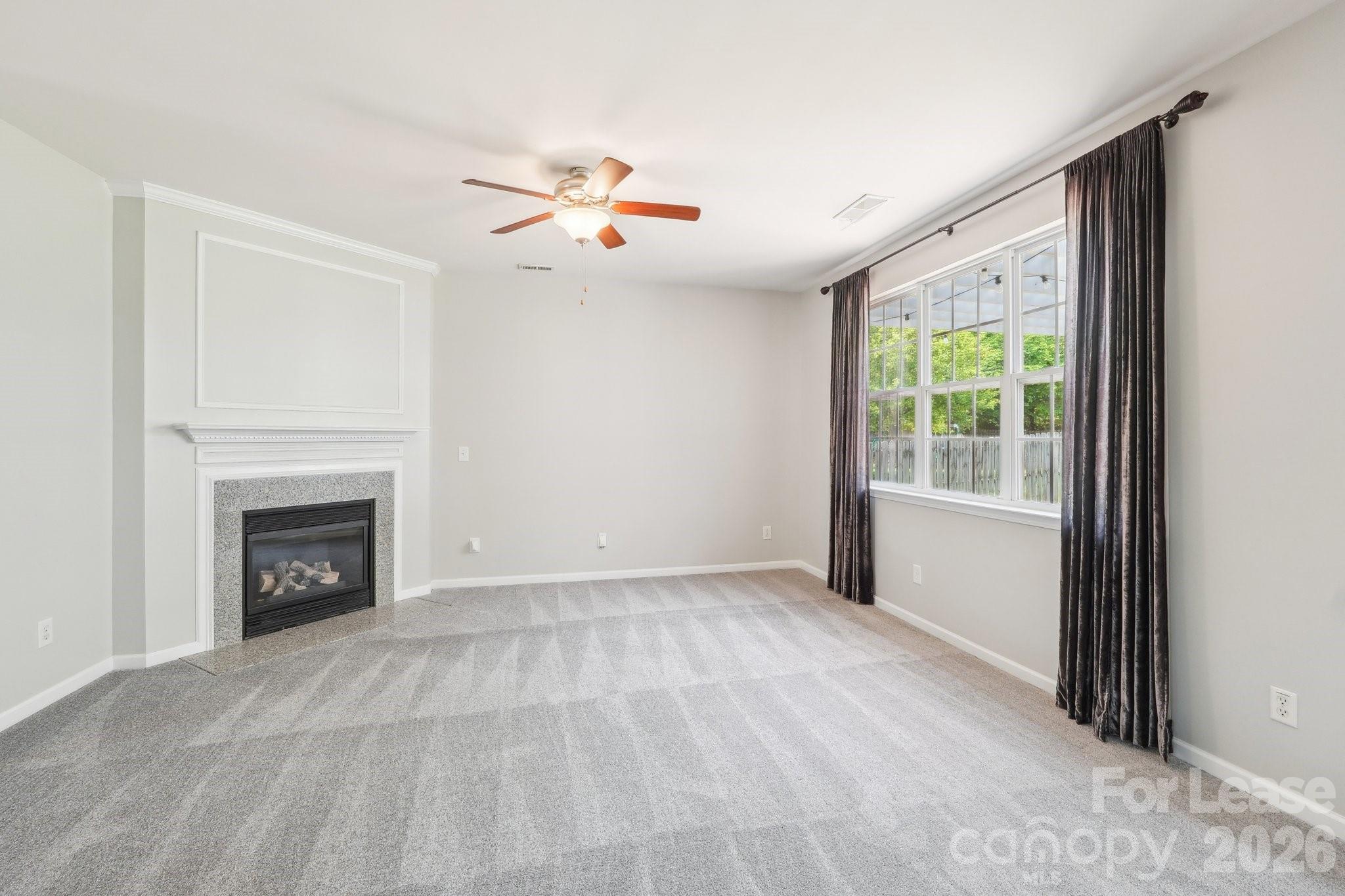 14417 Laurel Tree Lane Huntersville, NC 28078 - Photo 5 of 48 a view of empty room with a fireplace and fan