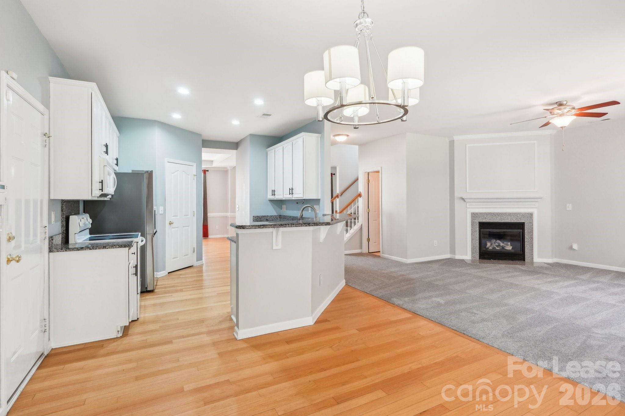 14417 Laurel Tree Lane Huntersville, NC 28078 - Photo 8 of 48 a open kitchen with cabinets a stove and a chandelier