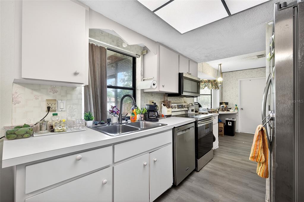 464 Coronado Road Venice, FL 34293 - Photo 8 of 28 a kitchen with stainless steel appliances sink a microwave and cabinets