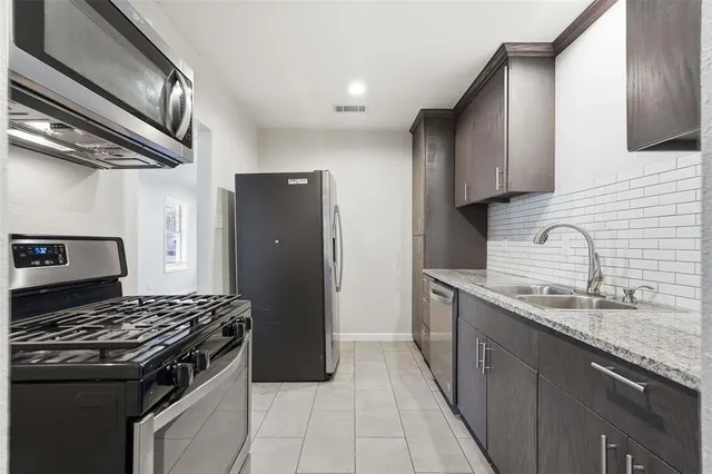 a kitchen with stainless steel appliances granite countertop a sink stove and refrigerator