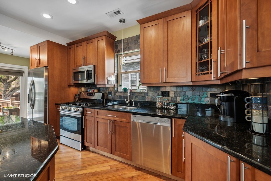 4340 North Harding Avenue Chicago, IL 60618 - Photo 5 of 14 a kitchen with stainless steel appliances granite countertop a stove a sink dishwasher and a microwave oven with cabinets