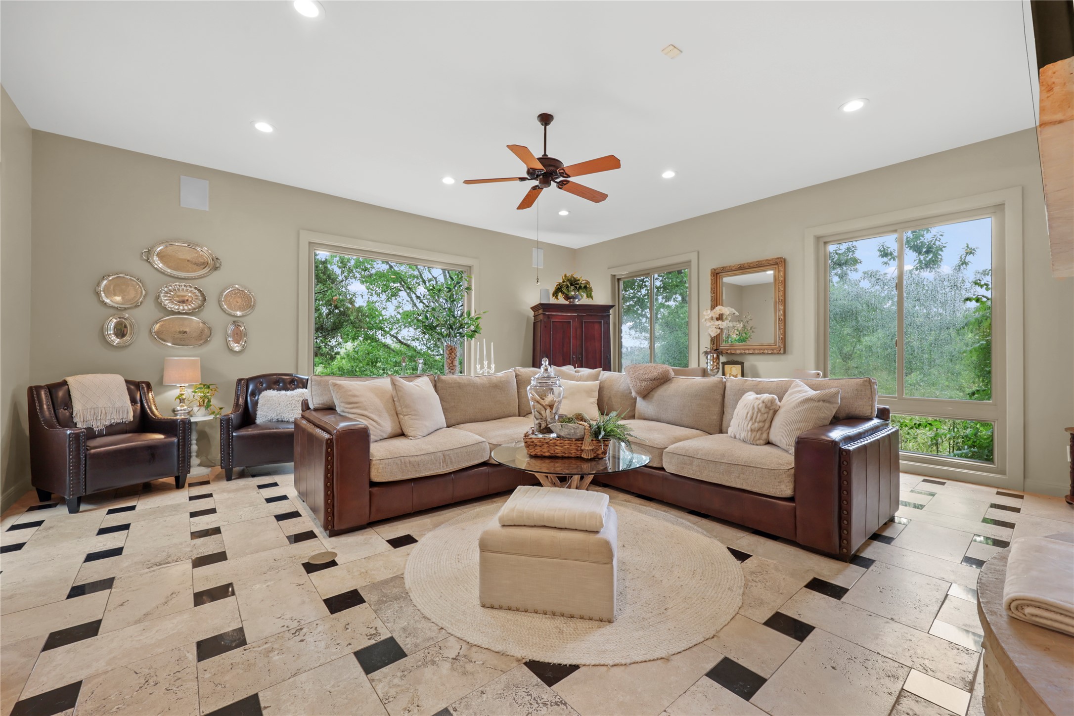 17501 Navigation Lane Lago Vista, TX 78645 - Photo 20 of 40 Spacious living/entertaining area featuring large windows providing natural light, a ceiling fan, and distinctive tiled flooring