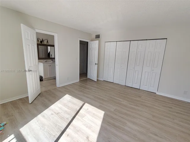 a view of a bedroom with wooden floor and closet
