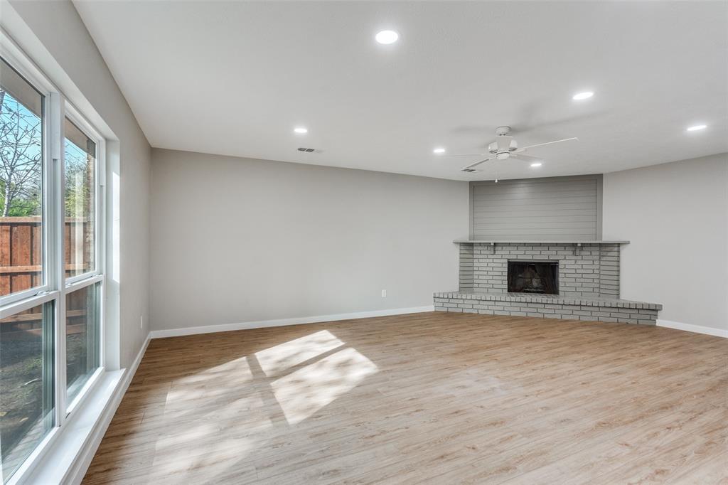 516 Ridgemont Drive Allen, TX 75002 - Photo 9 of 25 an empty room with wooden floor and a fireplace