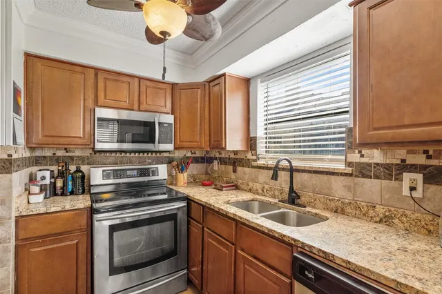 a kitchen with stainless steel appliances granite countertop a sink and a stove