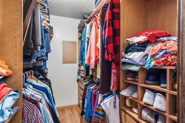 a view of walk in closet with clothes and shoes