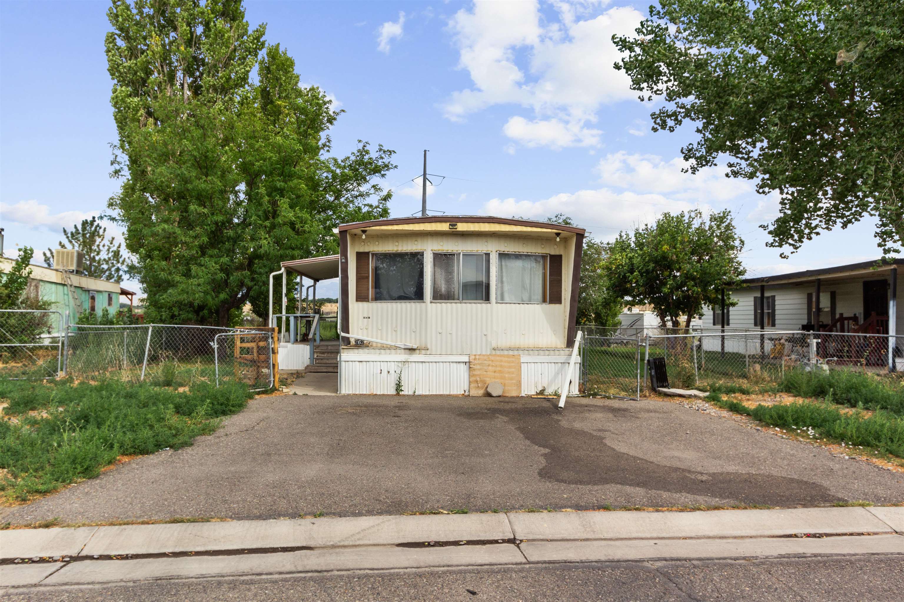 424 32 Road, Unit 262 Clifton, CO 81520 - Photo 2 of 16 a view of a white house next to a yard with large trees