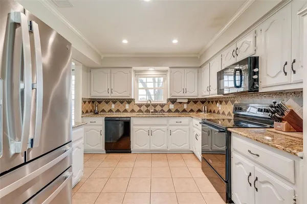 a kitchen with stainless steel appliances granite countertop a refrigerator sink and stove