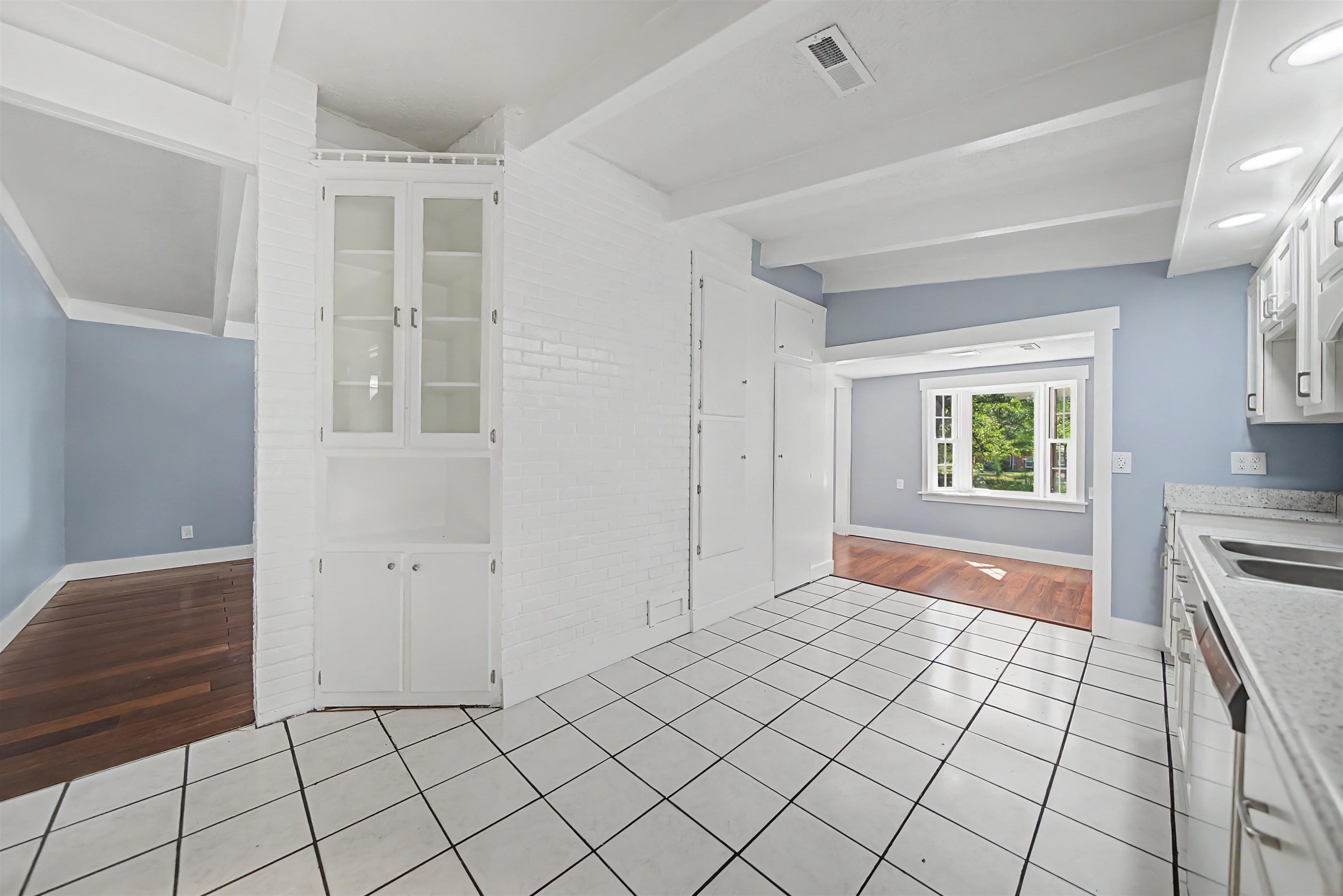 7437 Highway 45 Ramer, TN 38367 - Photo 16 of 36 White square tile flooring, exposed beam ceiling, built-in display cabinetry, double basin sink, and granite countertops