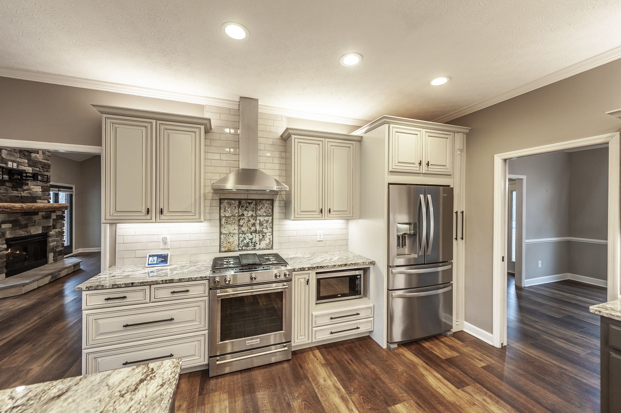 1133 Inneswood Drive Gallatin, TN 37066 - Photo 6 of 57 a kitchen with stainless steel appliances a stove a refrigerator and white cabinets with wooden floors