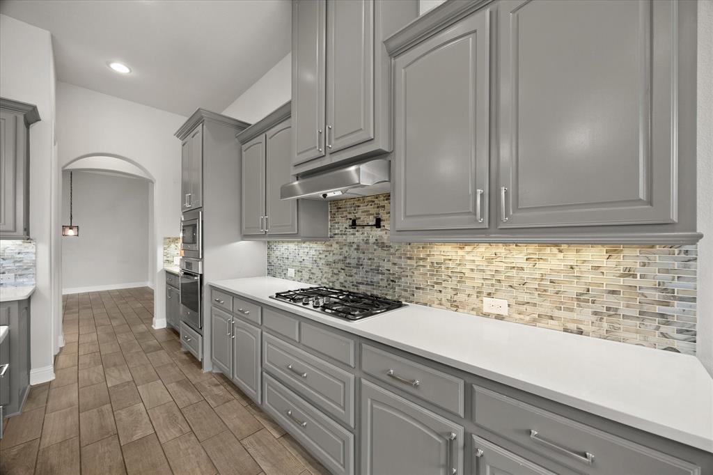 4861 Verbena Way Prosper, TX 75078 - Photo 17 of 38 a kitchen with stainless steel appliances granite countertop a sink stove and cabinets