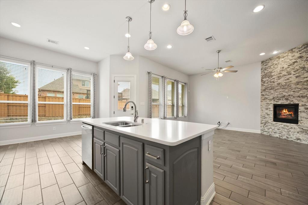 4861 Verbena Way Prosper, TX 75078 - Photo 19 of 38 an open kitchen with a sink and a stove top oven with wooden floor