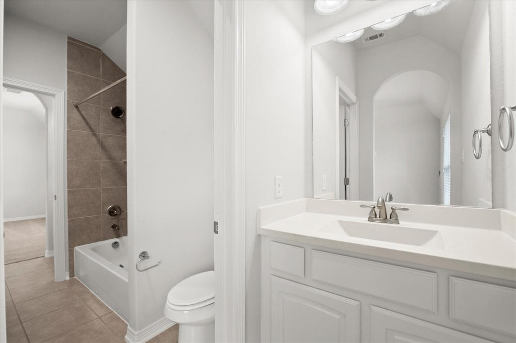 4861 Verbena Way Prosper, TX 75078 - Photo 28 of 38 a bathroom with a sink a toilet and a large mirror