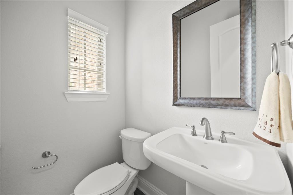 4861 Verbena Way Prosper, TX 75078 - Photo 8 of 38 a white toilet sitting next to a bathroom sink