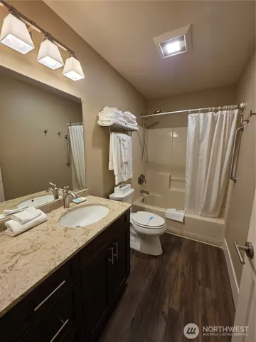 a bathroom with a granite countertop sink toilet and shower